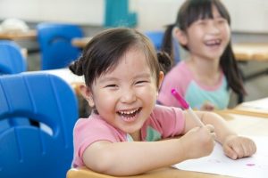 Little girl smiling while drawing - Home Tuition Hotspot Singapore