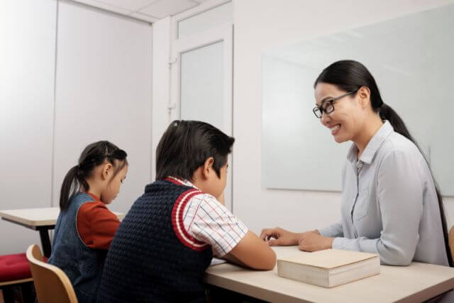 Singapore Home Tutor teaching two kids in a classroom setting