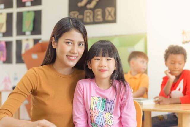 Singapore Home Tutor posing with a girl in a classroom setting